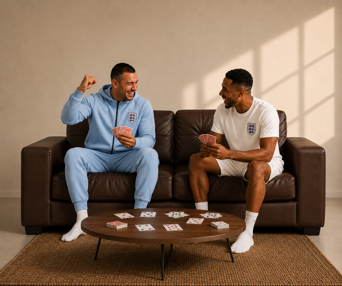 Two friends laughing over a game of cards on a SofaPack brown leather sofa